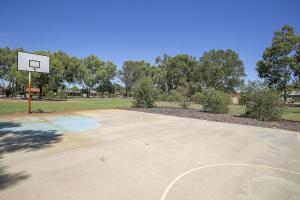 パースにあるKenwick Houseの公園内のフープ付き空きバスケットボールコート