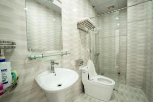 uma casa de banho branca com um WC e um lavatório em Riverside Row Apartment em Dong Hoi