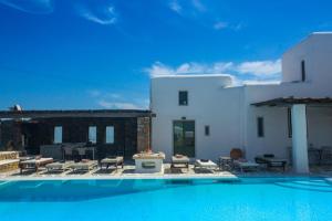 a swimming pool in front of a white building at Villa Irilia, Private Pool with Unrestricted Sea View in Fanari