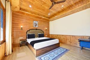 a bedroom with a bed in a room with wooden walls at OYO Itm Elysian in Vashisht