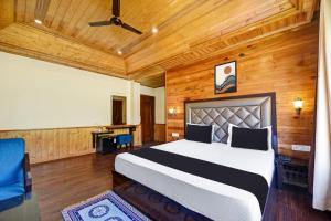 - une chambre avec un lit et un plafond en bois dans l'établissement OYO Itm Elysian, à Manali