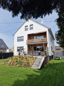 a white house with a porch on a lawn at Ut Huuske in Dorsel