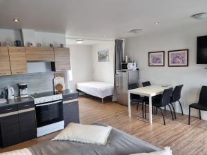 a living room with a kitchen and a table with chairs at Vestbjerg Apartments in Vestbjerg