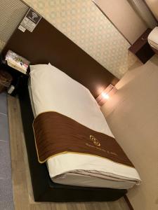 X ホテル（レジャーホテル） في Sayama: سرير في غرفة مع ضوء عليه