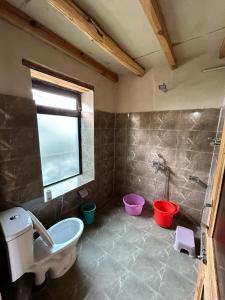 a bathroom with a tub and a toilet and buckets at Mystic Pangong in Spangmik