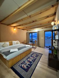 a bedroom with a large bed with a view of the ocean at Mystic Pangong in Spangmik