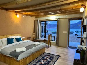 a bedroom with a bed and a view of the water at Mystic Pangong in Spangmik +38 photos