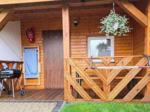 una veranda anteriore di una baita di tronchi con recinzione in legno di Holiday homes in Mi dzyzdroje for 4 people a Międzyzdroje