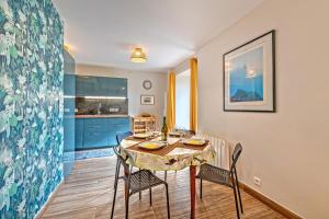 uma cozinha e sala de jantar com mesa e cadeiras em Kelenn - Maison avec jardin et terrasse em Plougastel-Daoulas