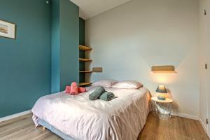 um quarto com uma cama com uma parede azul em Kelenn - Maison avec jardin et terrasse em Plougastel-Daoulas