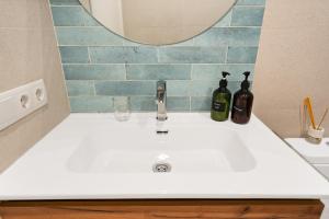 a bathroom sink with two bottles and a mirror at Lodging Apartments Beach Studio 22 in Barcelona