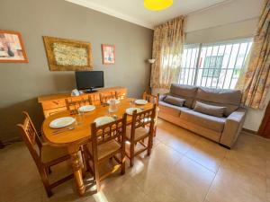 a living room with a table and a couch at Bungalows Pescador in Segur de Calafell