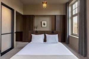1 dormitorio con 1 cama blanca grande y 2 ventanas en New Park Edition, en Venlo