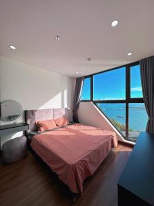 una camera con un letto e una grande finestra di Green Diamond Homestay Hạ Long a Ha Long