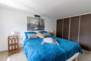 une chambre avec un lit avec une couverture bleue dans l'établissement Cocon à deux minutes de la mer., à Propriano