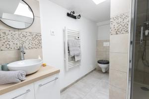 une salle de bain avec un lavabo, des toilettes et un miroir dans l'établissement Cocon à deux minutes de la mer., à Propriano