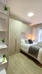 a bedroom with a bed and a large cabinet at Belíssimo Apto com lareira e piscina aquecida! in Gramado