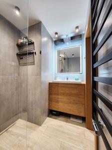a bathroom with a sink and a mirror at Apartament niebiańskie Pogodno in Szczecin