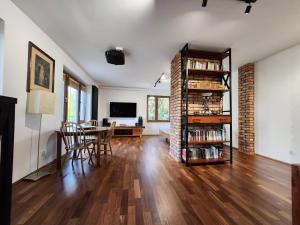 a living room with a table and a book shelf at Apartament niebiańskie Pogodno in Szczecin