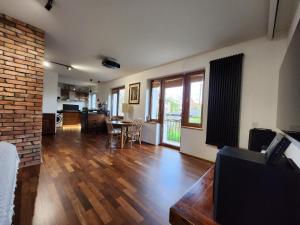 a living room with wooden floors and a brick wall at Apartament niebiańskie Pogodno in Szczecin
