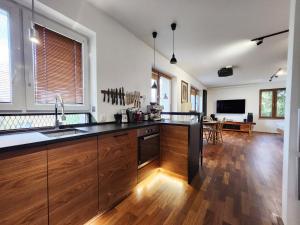 a kitchen with wooden cabinets and a counter top at Apartament niebiańskie Pogodno in Szczecin