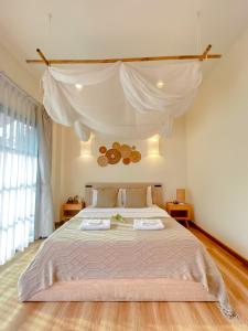 a bedroom with a large bed with a white canopy at Chamonte Pool Villa Khao Yai in Ban Muak Lek Nai