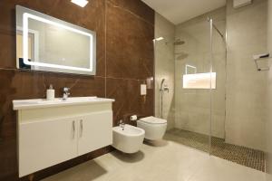 a bathroom with a toilet and a sink and a shower at Grandstay Portside in Durrës