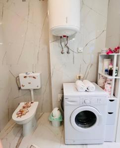 a bathroom with a washing machine and a toilet at Apartment M&M Izola in Izola +46 photos