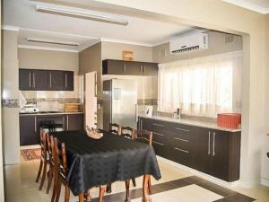cocina con mesa negra y sillas en una habitación en GOODWILLMANOR en Durban