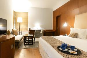 a hotel room with a bed and a living room at The Manor - New Delhi in New Delhi
