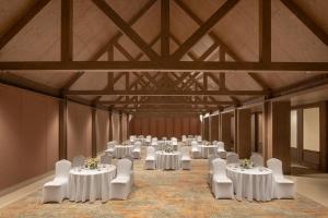 un salón de banquetes con mesas blancas y sillas blancas en ZANA - A Luxury Escape, Dhikuli, Jim Corbett en Garjia