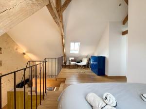 een slaapkamer op zolder met een bed en een trap bij Superbe Grange et son bain nordique, endroit paisible du Perche in Soligny-la-Trappe