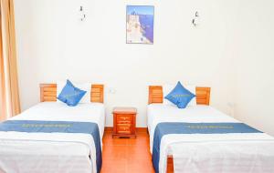 a room with two beds with blue and white sheets at lotus hotel 2 khách sạn bắc ninh in Bắc Ninh