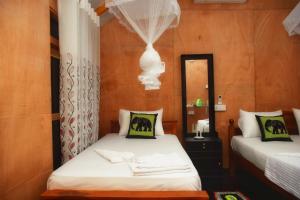 sypialnia z dwoma łóżkami i lustrem w obiekcie Akash Treehouse w mieście Sigirija