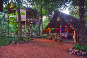 a gazebo in a forest with christmas lights at Akash Treehouse in Sigiriya