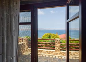 a room with a view of the ocean through a window at Ethaleia Hotel in Moúdhros