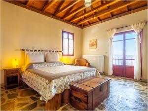 a bedroom with a bed and a wooden ceiling at Ethaleia Hotel in Moúdhros