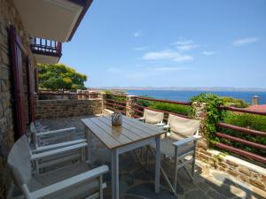 una mesa y sillas en un patio con vistas al océano en Ethaleia Hotel, en Moúdhros