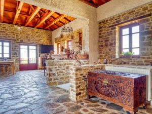 a large room with a stone wall and a wooden chest at Ethaleia Hotel in Moúdhros