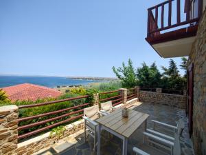a patio with a table and chairs on a balcony at Ethaleia Hotel in Moúdhros