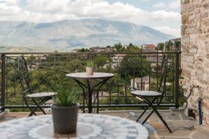 einen Tisch und Stühle auf einem Balkon mit Aussicht in der Unterkunft DAM Stone Boutique Hotel in Gjirokastër