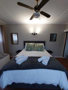 um quarto com uma cama grande e uma ventoinha de tecto em Coral Cottage em Hilton