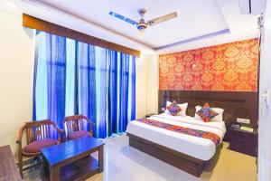 1 dormitorio con 1 cama, mesa y sillas en FabHotel Green view palace, en Indirapuram