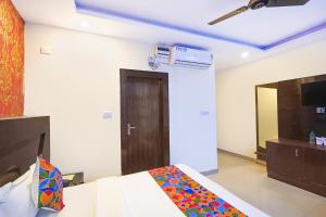 a bedroom with a bed and a ceiling fan at FabHotel Green view palace in Indirapuram