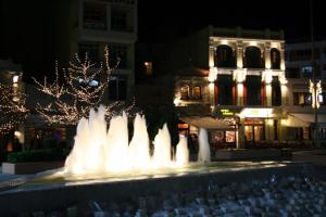 a fountain with lights in a city at night at Astoria Hotel Traditional in Komotini