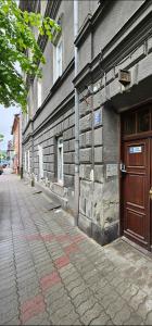 - un bâtiment en briques avec une porte en bois dans une rue dans l'établissement Apartament Studio Old City, à Przemyśl