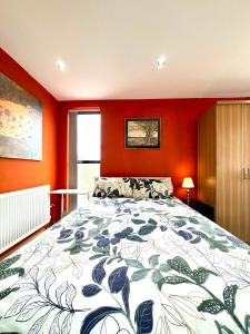 una camera da letto con un grande letto con pareti arancioni di The Crib - 1 Bedroom Apartment Central London by Wild Boutique a Londra