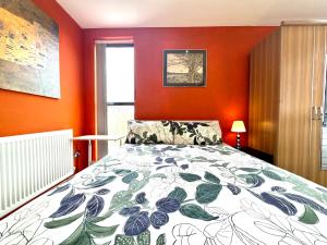 una camera da letto con pareti arancioni e un letto con una coperta di The Crib - 1 Bedroom Apartment Central London by Wild Boutique a Londra