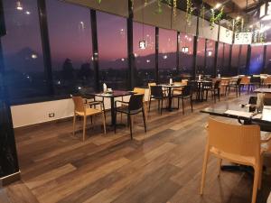 ケツァルテナンゴにあるHotel Luna de Plata Aeropuertoのテーブルと椅子、大きな窓のあるレストラン