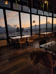 un restaurante con mesas y sillas en una habitación con ventanas en Hotel Luna de Plata Aeropuerto, en Quetzaltenango